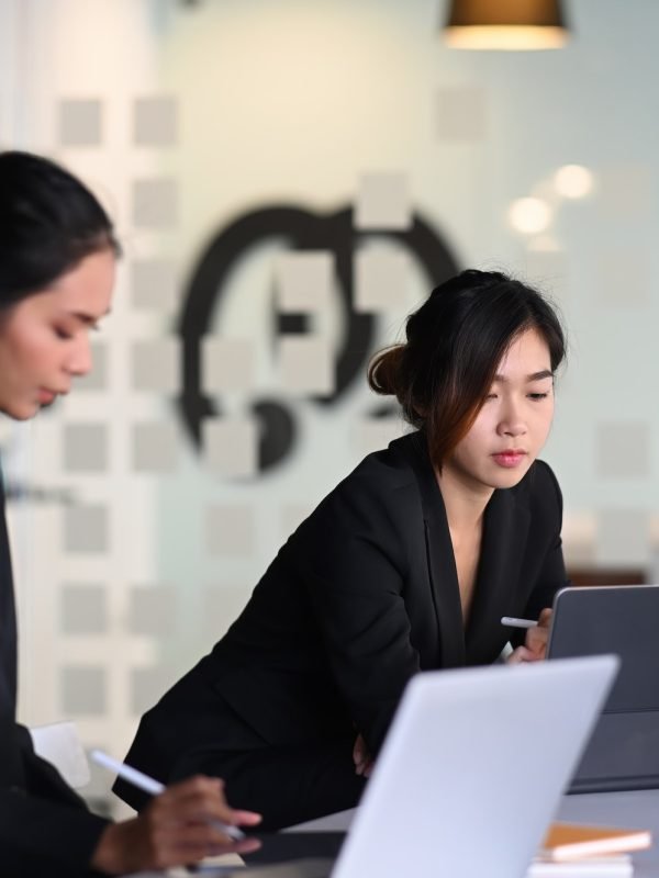 Businesswoman in suit experts discussing information during accounting process in office.
