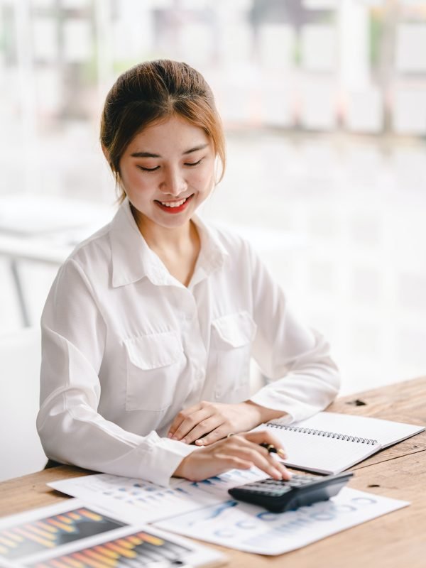 Portrait of an Asian woman working on a tablet computer in a modern office. Make an account analysis