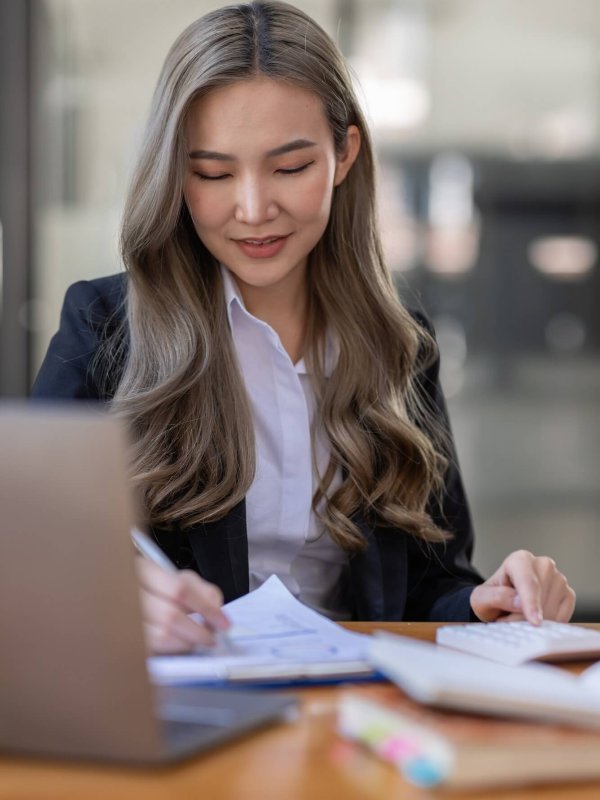 business Asian woman or accountant Bookkeeper working on calculator to calculate business data,