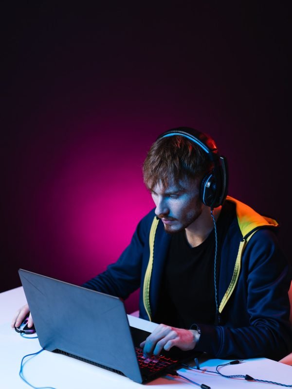 Hacker it genius using laptop writing code wearing hood on head. Cyber security concept