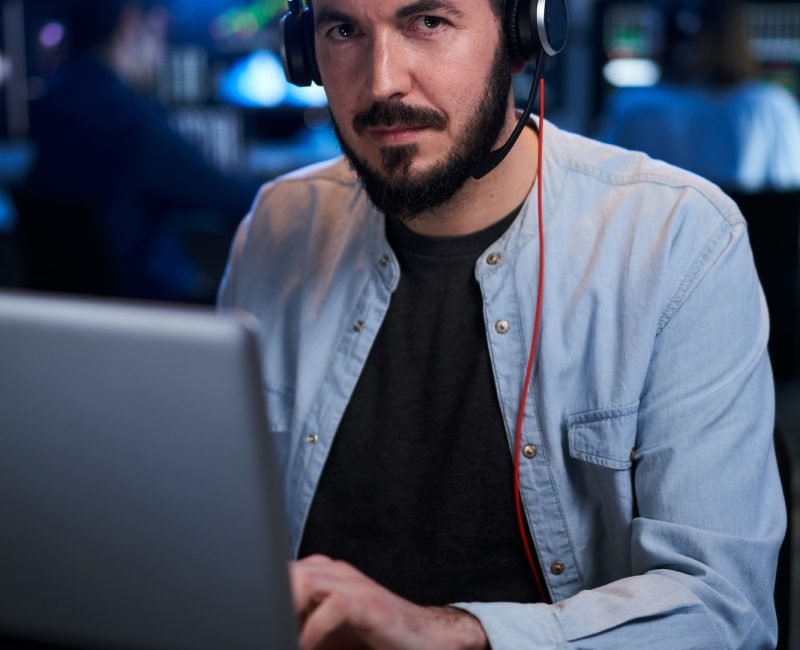 Vertical Portrait looking at camera of a Stock Market Trader Working Investment Charts,