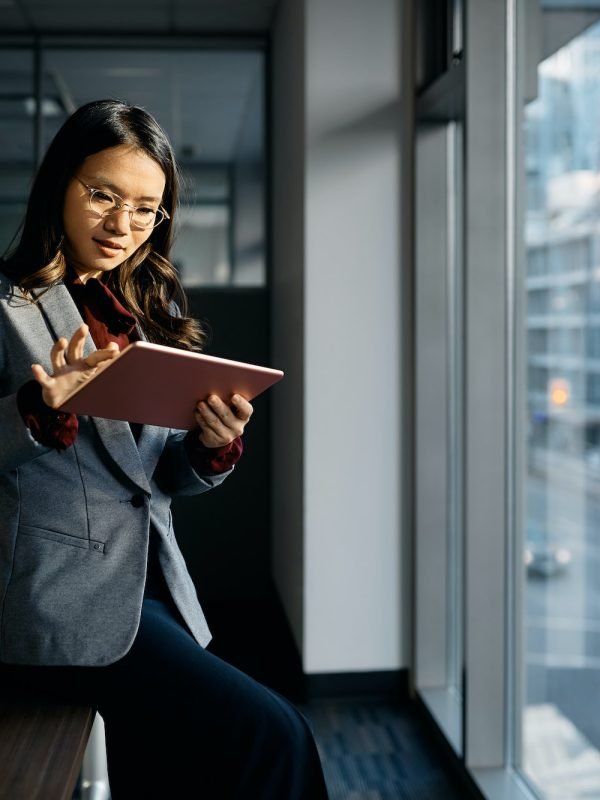 Asian businesswoman working on digital tablet in the office.