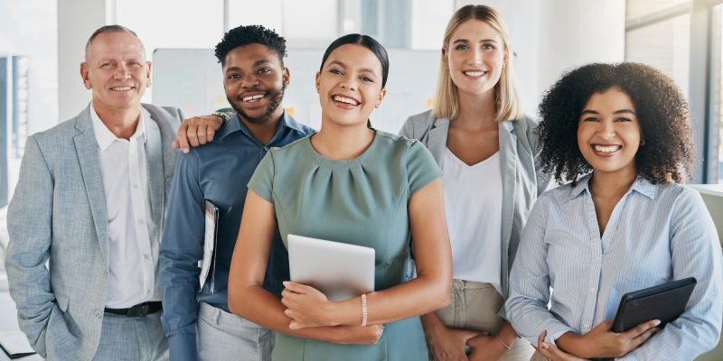 Portrait, happy or business people in a digital agency in an office building with motivation, goals