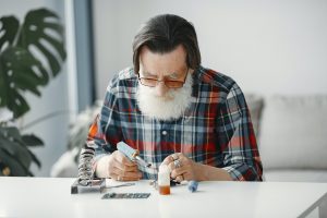 Male tech repairs electronic equipment at home