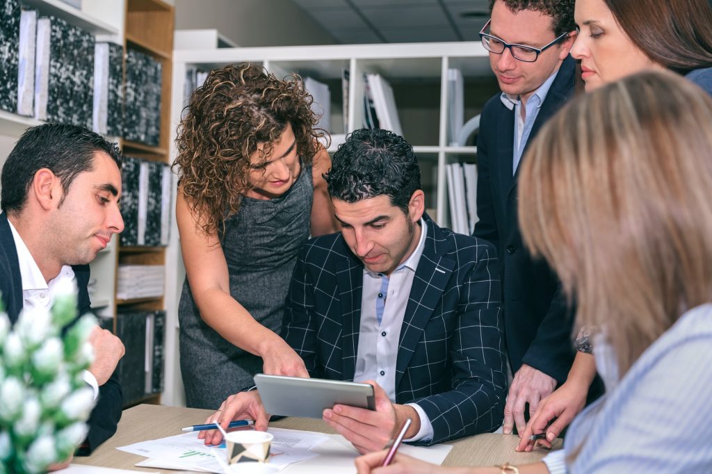 Teamwork looking business document in electronic tablet