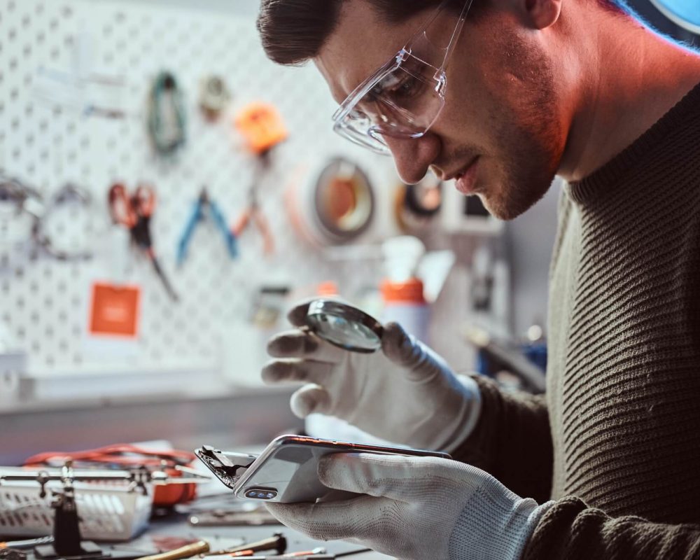 electronic-technician-repair-damaged-smartphone-in-the-workshop