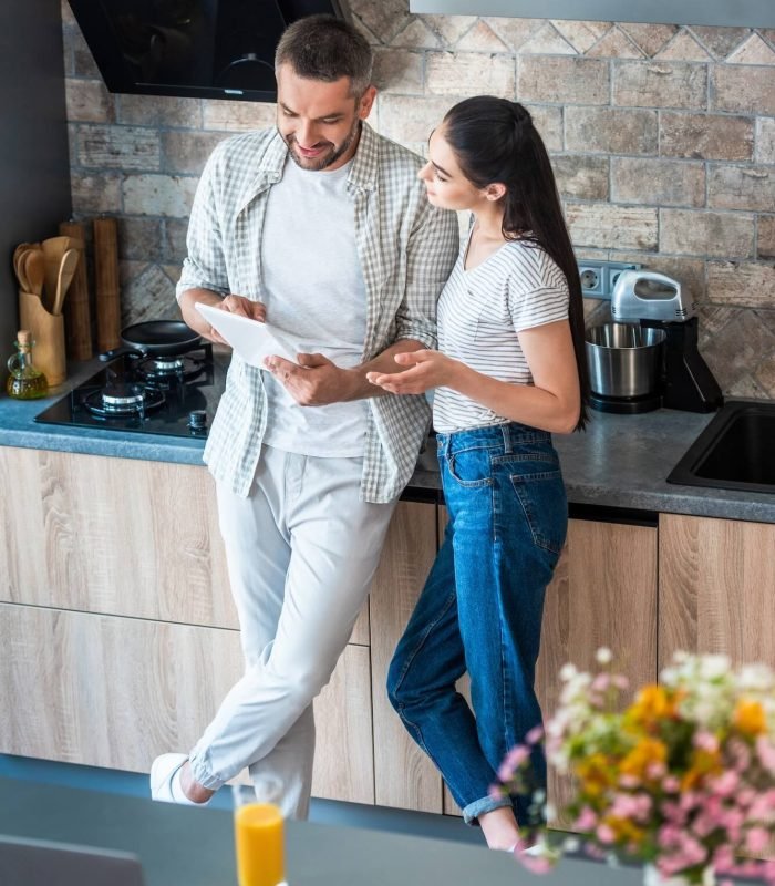 married-couple-using-digital-tablet-together-in-kitchen-smart-home-concept
