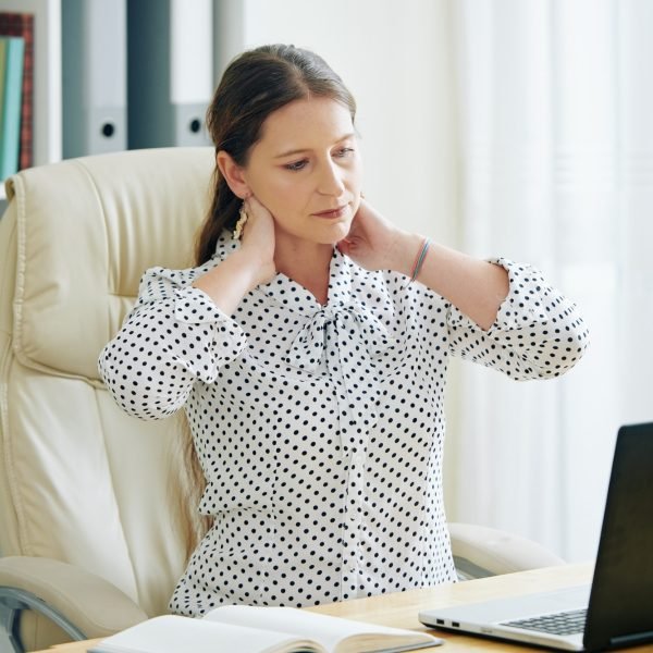 Businesswoman rubbing stiff neck