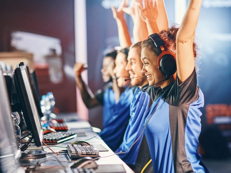 oung multiracial team of happy professional cyber sport gamers celebrating