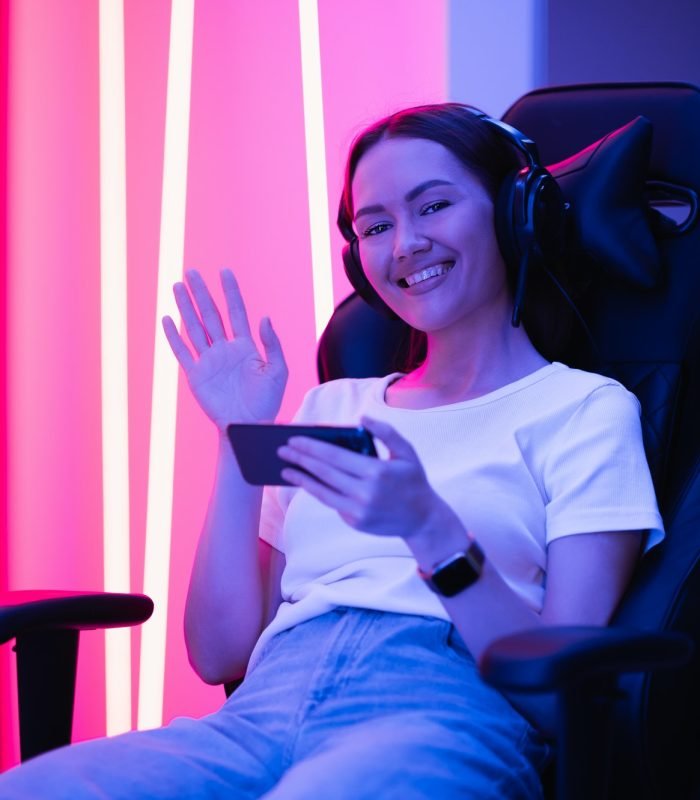 Young female teenage cyber sport gamer play mobile game by smartphone on eSport tournament