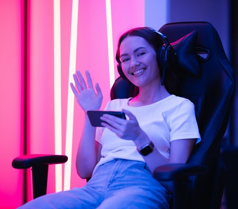 Young female teenage cyber sport gamer play mobile game by smartphone on eSport tournament