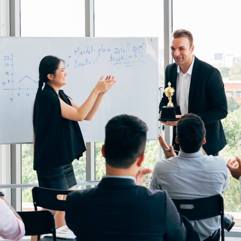 Boss awarding workers during conference