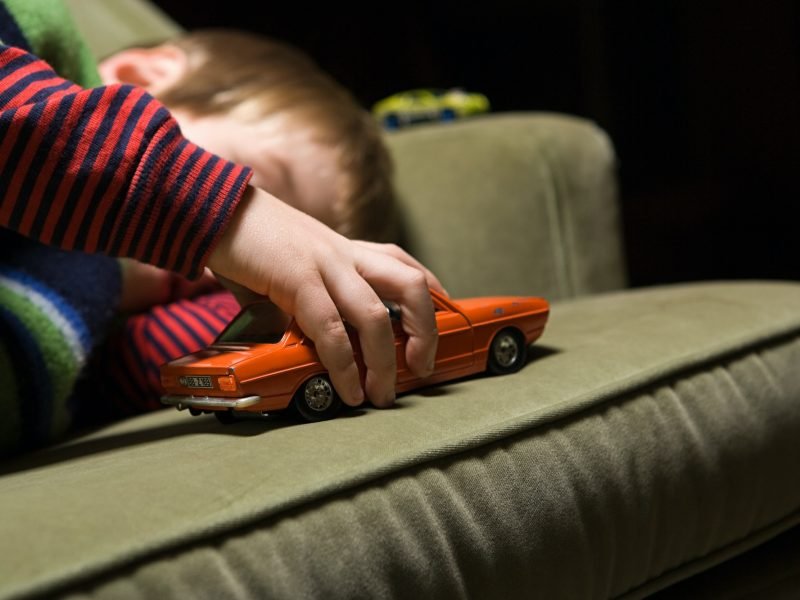 Boy playing with a toy car