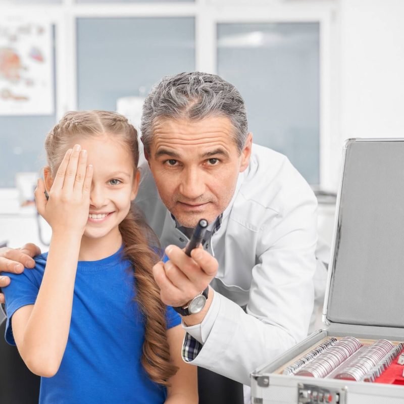 girl-closing-eye-with-hands-and-looking-at-camera-in-clinic