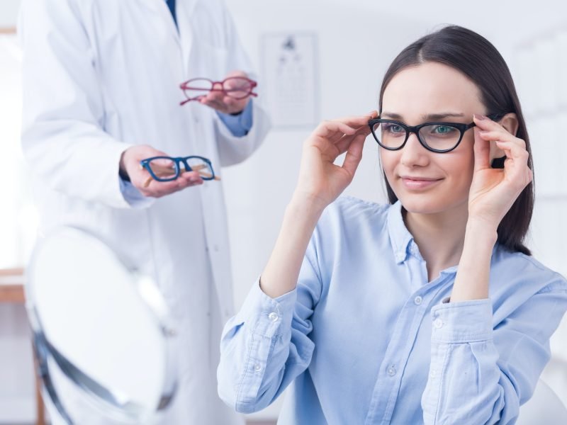Optician with eyeglasses and client