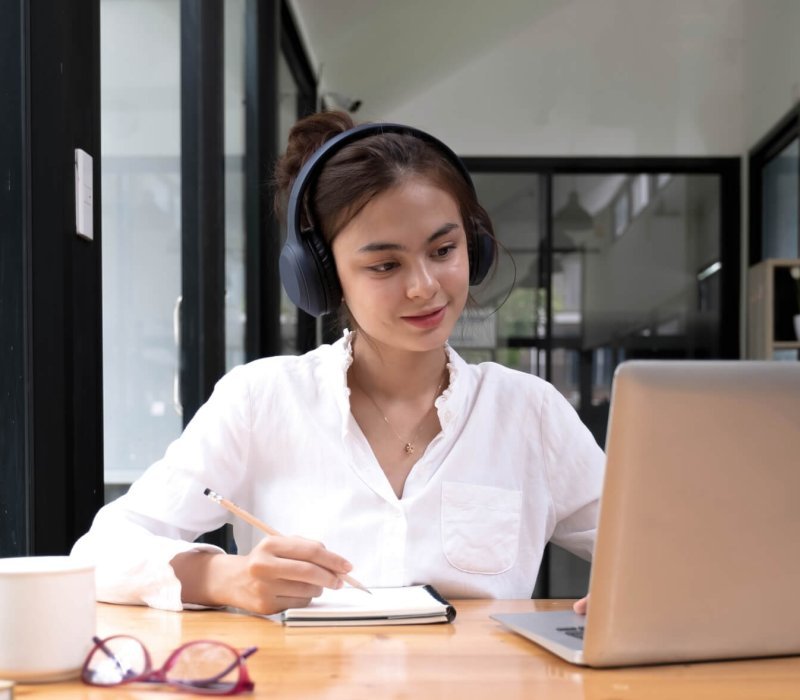 asian woman interpreter write translation from foreign language to english listen to audio record in