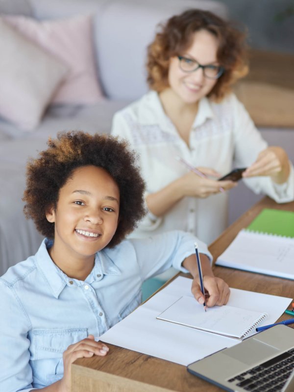 Radiate happiness. Happy mixed race teen schoolgirl smiling at camera while having a lesson with