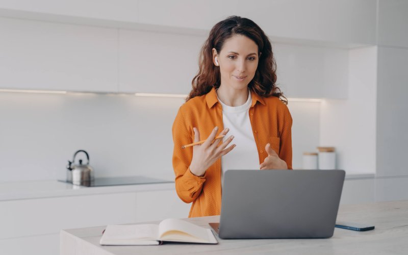 Tutor has lesson online on computer. Young pretty woman teaching students language online.