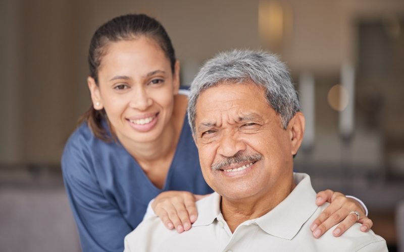 Portrait of elderly man with a nurse, bonding during a checkup at assisted living homecare . Smile,