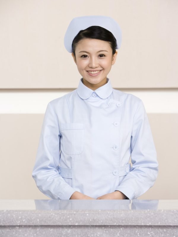 Young Nurse Poised At Nurses' Station