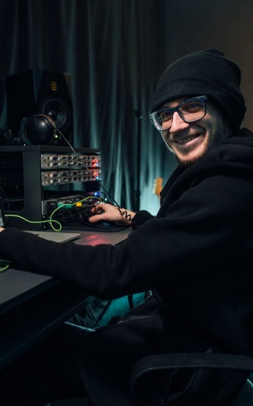 A sound engineer uses a mixing board and software to create audio track.