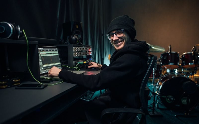 A sound engineer uses a mixing board and software to create audio track.