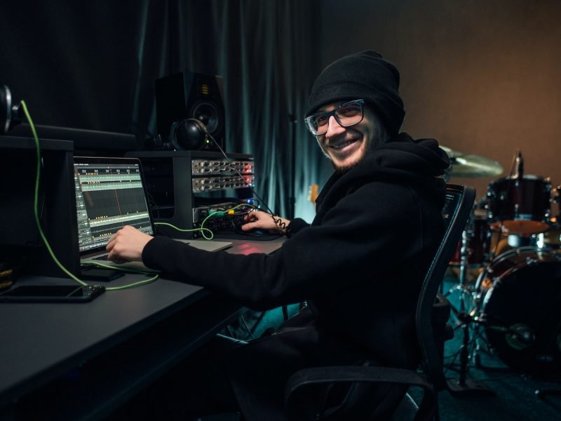 A sound engineer uses a mixing board and software to create audio track.