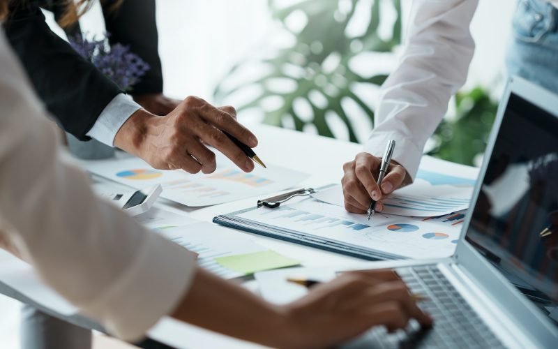 Business people pointing to graph and chart to analyze market, sale, balance sheet, account, net pro