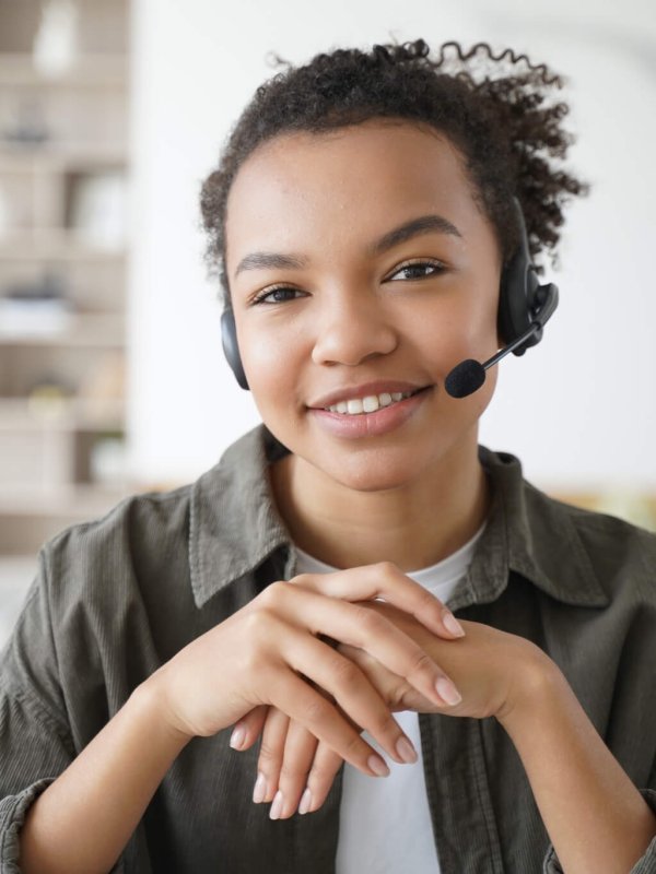 Virtual assistant. Young afro woman in headset is operator of client support service from home.