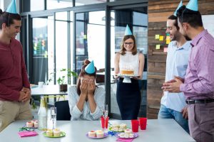 Businesspeople giving surprise birthday party to colleague